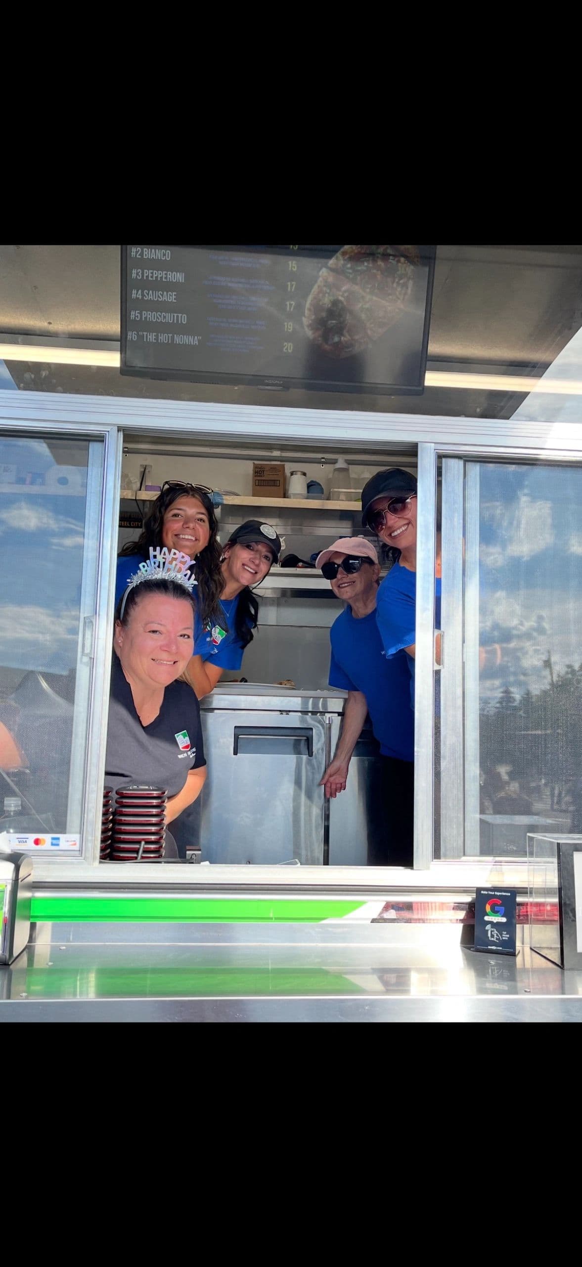 The When In Rome crew at work inside the truck, serving from the window